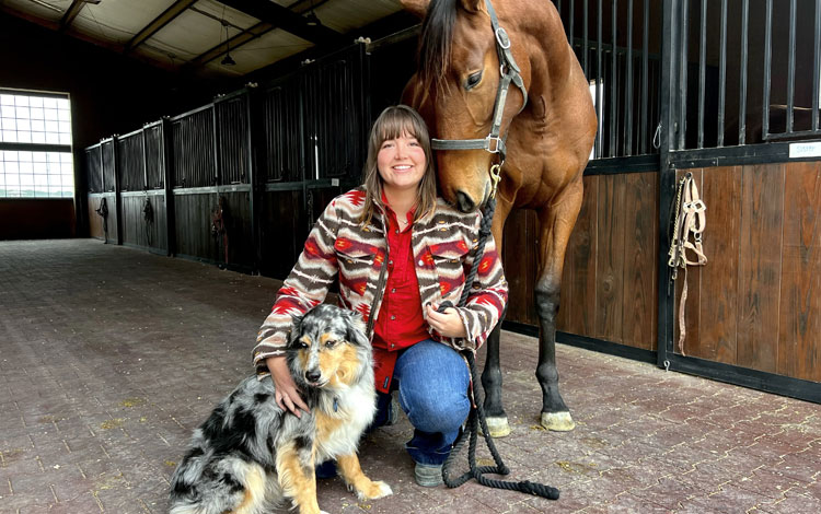 Abby, posing next to her horse and her Australian shepherd dog.